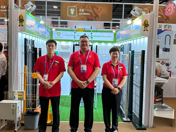 Giant Fence team in white shirts at 140th Canton Fair booth, thumbs-up for metal fencing.