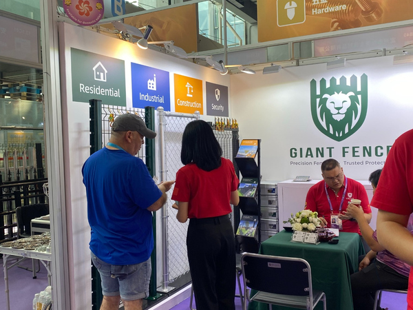 At 140th Canton Fair, a visitor reviews metal fence products at Giant Fence booth.