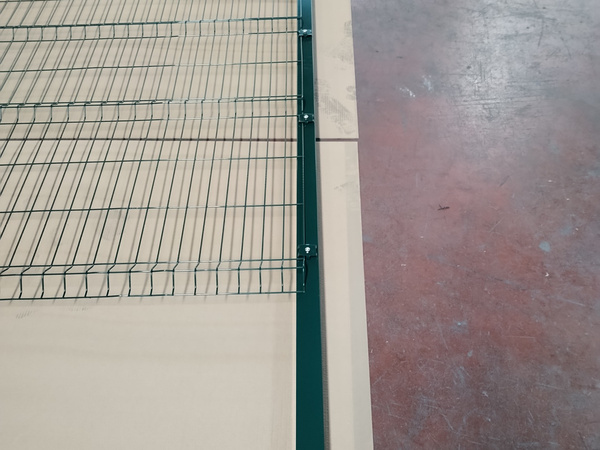 El panel de la valla de malla soldada 3D se conecta al poste cuadrado con sujetadores en el taller.