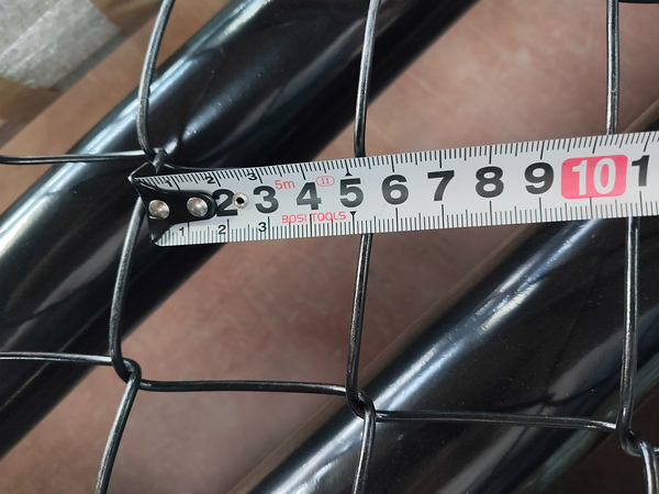 Tape measure checks mesh opening size of our chain link fence product.