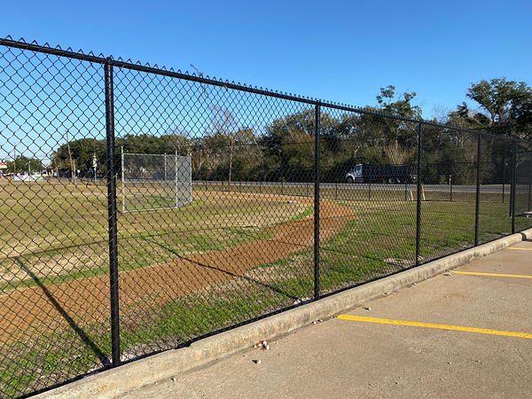 Black coated chain link fence installed on site for sports field perimeter protection.