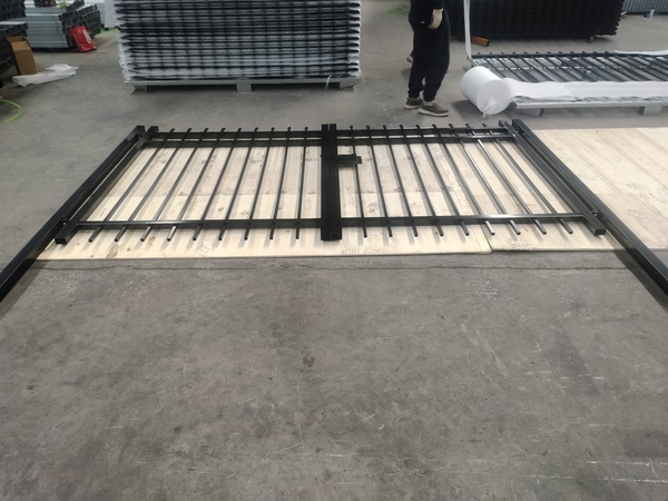 Factory inspection of finished black steel tubular fence gate before packing.