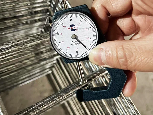 A QC worker is measuring the wire diameter of 3D fence.