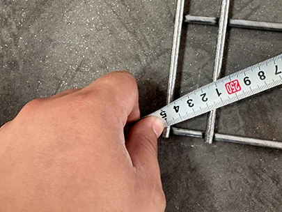 A QC worker is measuring the flatness of edge protection fence.