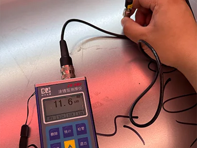 A QC worker is testing the zinc thickness of steel plate.
