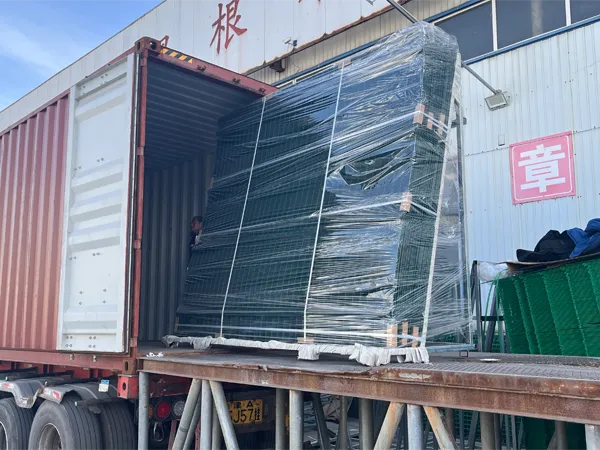 A pallet of wrapped 358 security fence is being loaded into a container at a factory.