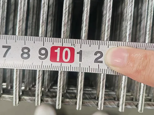 A QC worker is measuring the mesh size of 358 high security fence.