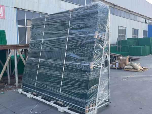 In a factory yard, stacked 358 security fences (wrapped) and other green fences are stored, ready for shipping.