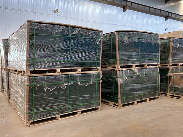 Several wooden pallets of green 3D fences.