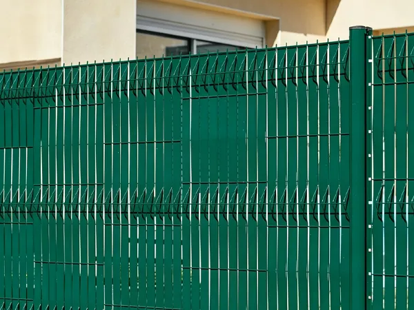 3D privacy fence with green privacy tape installed through the fence mesh.