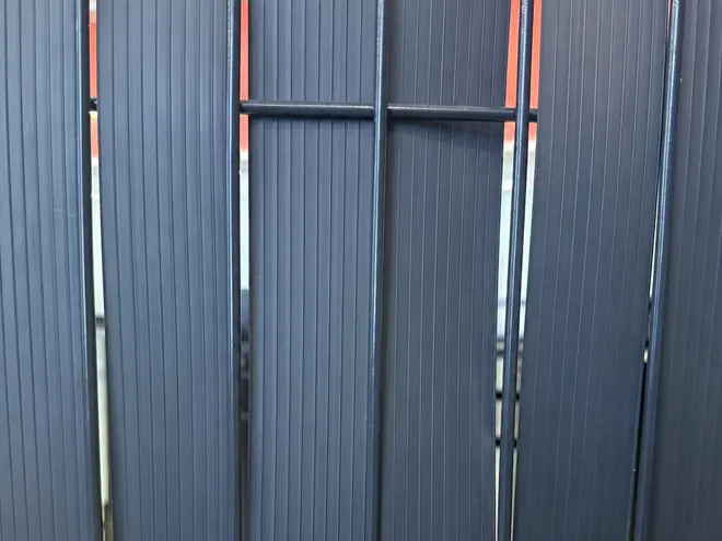 3D privacy fence with privacy slats interlaced through the wire mesh.
