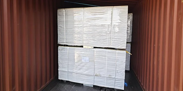 Several metal pallets of steel tubular fences in the container.