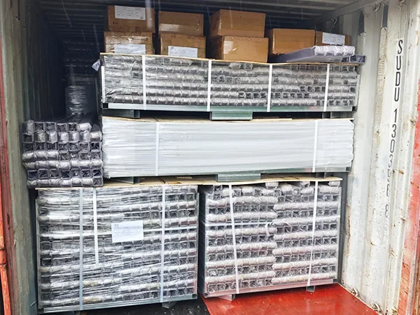 Several metal pallets of steel tubular fence posts in the container.