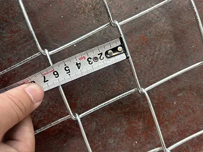 A QC worker is measuring the hole size of American temporary fence with meter tape.