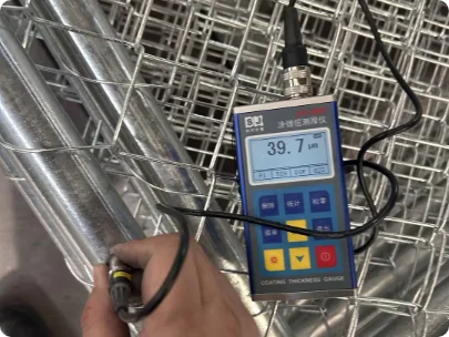 A QC worker is testing the zinc thickness with tools.