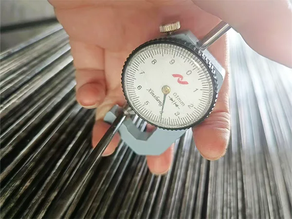 A QC worker is measuring the wire diameter of High Security Fence.
