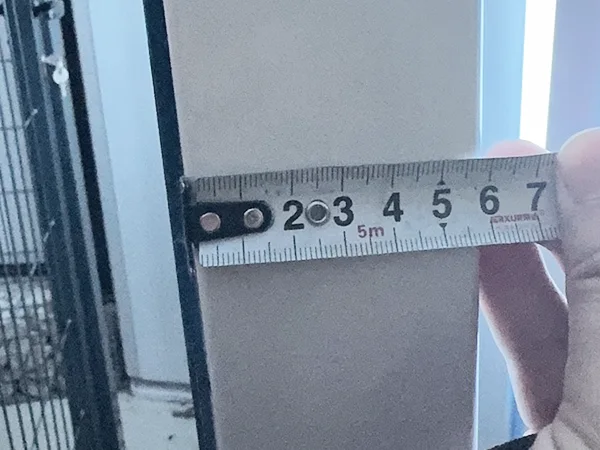 A QC worker is measuring the post size of 3D panel type airport fence.