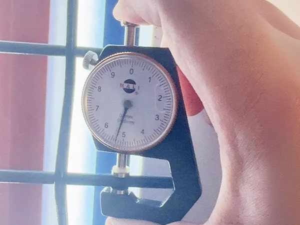 A QC worker is measuring the wire diameter of 3D panel type airport fence.