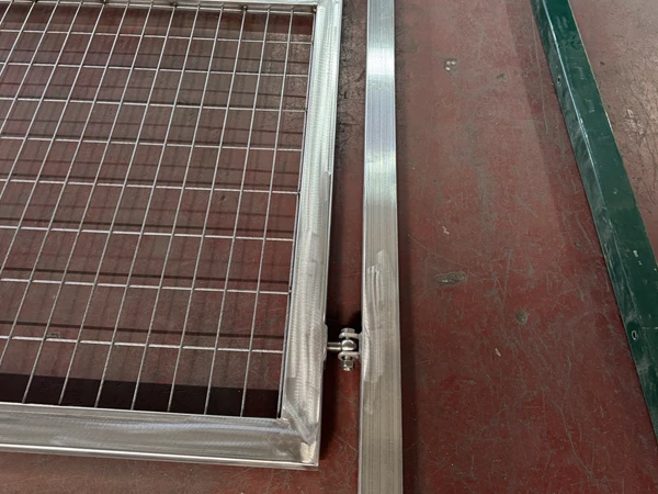Hinge close-up of metal mesh gate, component of airport fencing system