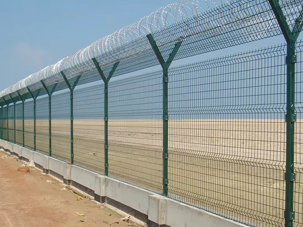 Installed airport fencing system with concertina razor wire on concrete base