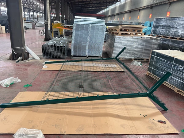 Green Y mesh panel laid flat, unfinished airport fencing system in warehouse