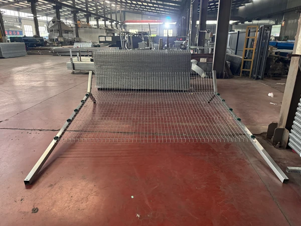 Silver Y mesh panel unfolded on factory floor, airport fencing system prototype