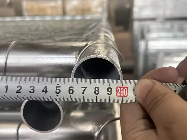 A QC worker is measuring the frame size of American temporary chain link fence.