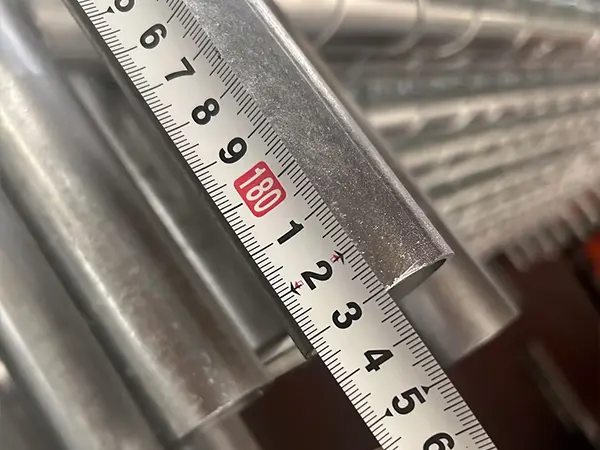A QC worker is measuring the panel height of American temporary chain link fence.