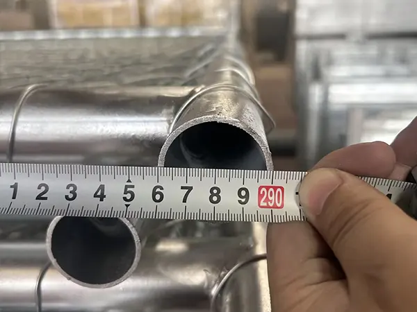 A QC worker is measuring the width of American temporary chain link fence.