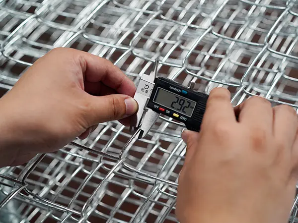 A QC worker is measuring the wire diameter of American temporary chain link fence.