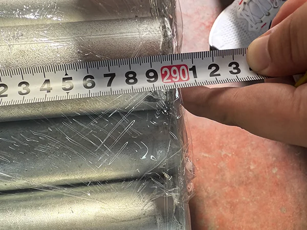 A QC worker is measuring the post length of chain link fence.