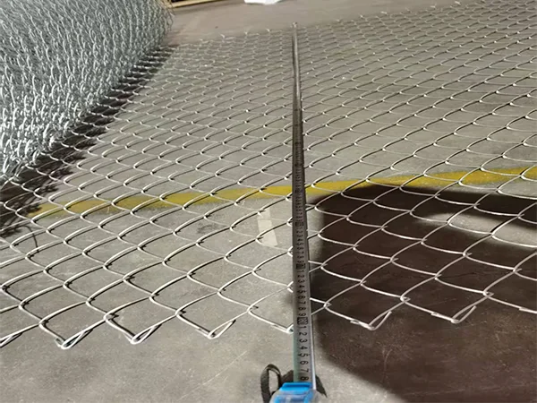 A QC worker is measuring the wire diameter of chain link fence.