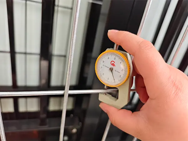 A QC worker is measuring the wire diameter of Australia Temporary Fencing.