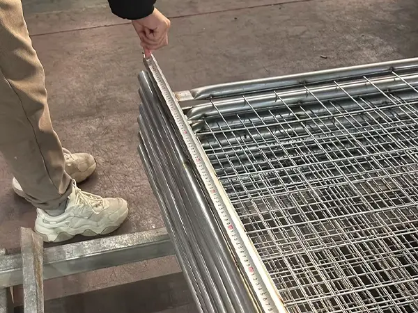 A QC worker is measuring the panel height of Australia Temporary Fencing.