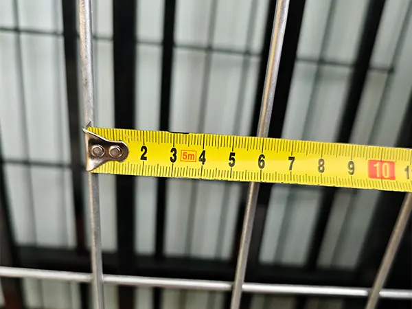 A QC worker is measuring the mesh size of Australia Temporary Fencing.