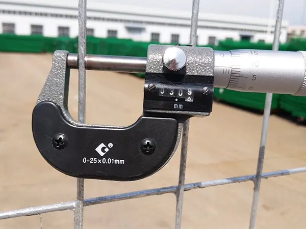 A QC worker is measuring the wire diameter of Canada temporary fence.