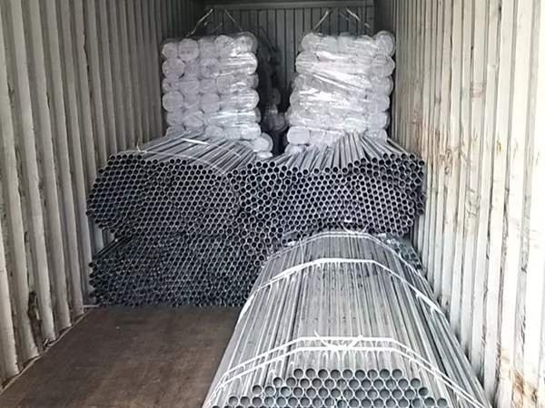 Several bundles of chain link fence posts in the container.