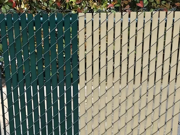 Chain link fence with plastic privacy slats installed along a perimeter.