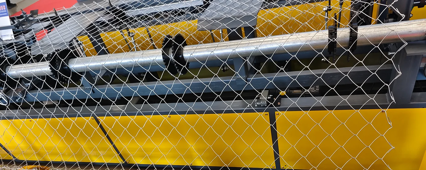 A chain link fence equipment is working.