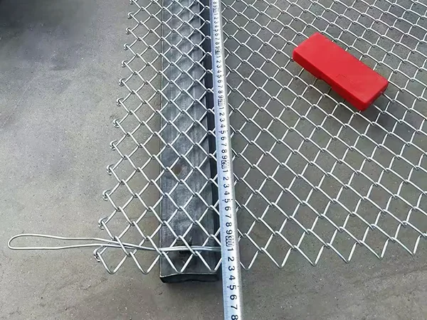 A QC worker is measuring the length of chain link fence.