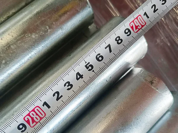 A QC worker is measuring the post length of chain link fence.