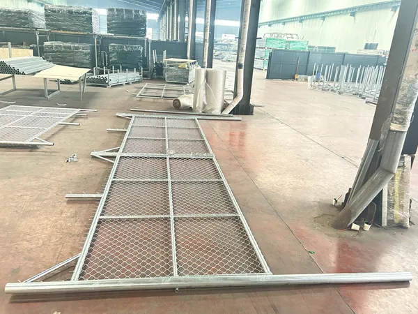 A pre-assembled chain link fencing system panel lies on the factory floor for inspection.