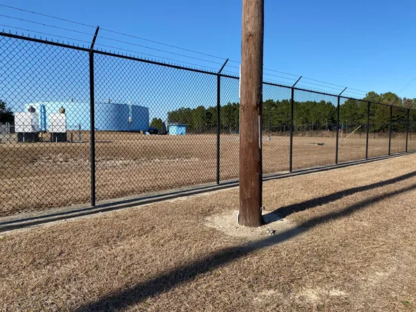 The complete black chain link fencing system runs along the perimeter of the facility.