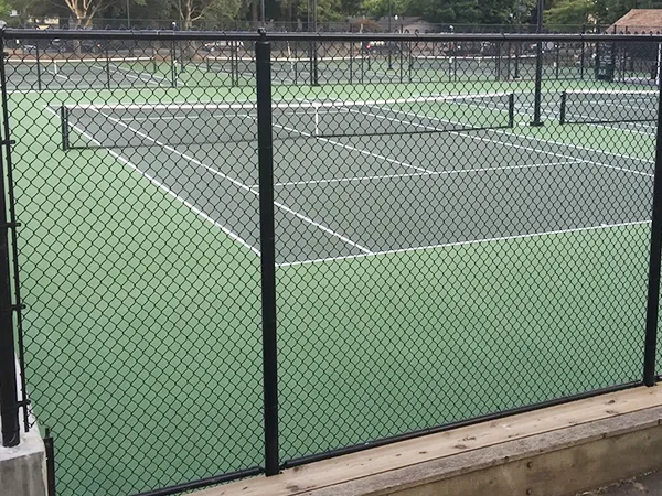 The chain link sports fences are installed in the tennis court.