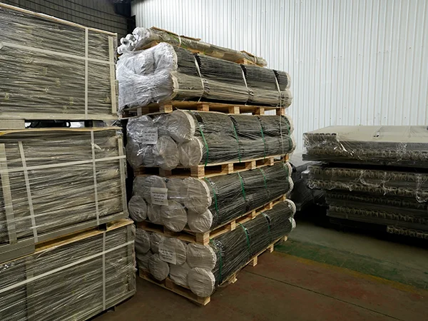 Several wooden pallets of chain link sports fences in the warehouse.