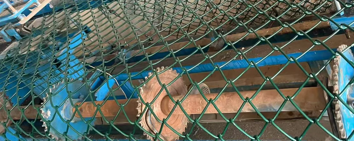 A chain link fence equipment is working.