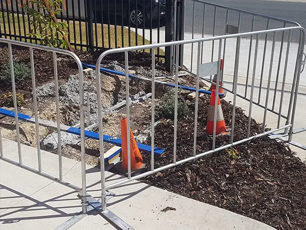 The crowd control barriers are surrounding the construction site.