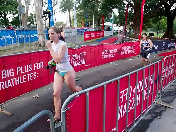 A racer is running at the crowd control barriers passage.