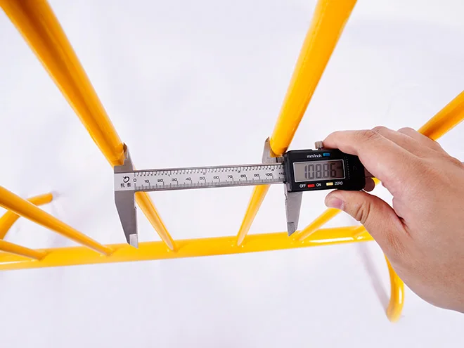 A QC worker is measuring the vertical tube distance of crowd control barrier.
