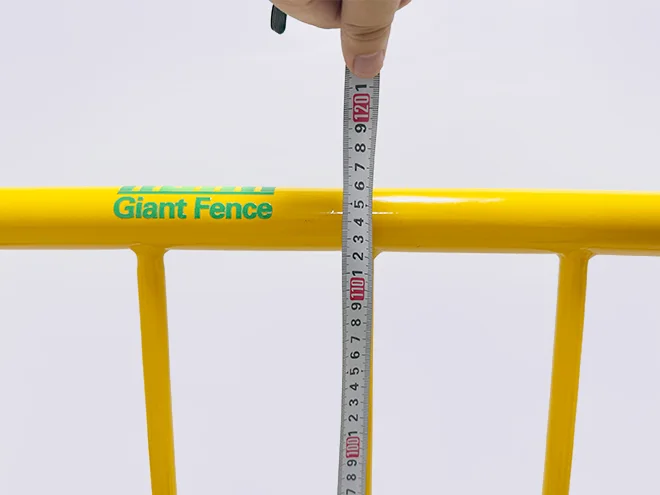 A QC worker is measuring the height of crowd control barrier.